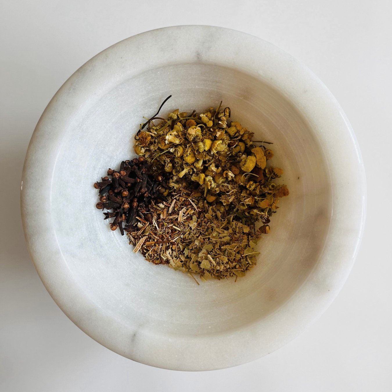 A variety of dried herbal tea leaves and flowers, including chamomile and linden, commonly used in sleep-promoting tea blends.