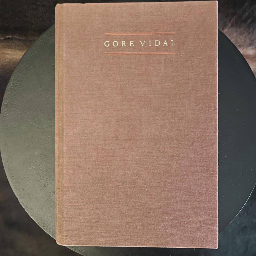 Brown book with 'Gore Vidal' on the cover, placed on a dark surface.