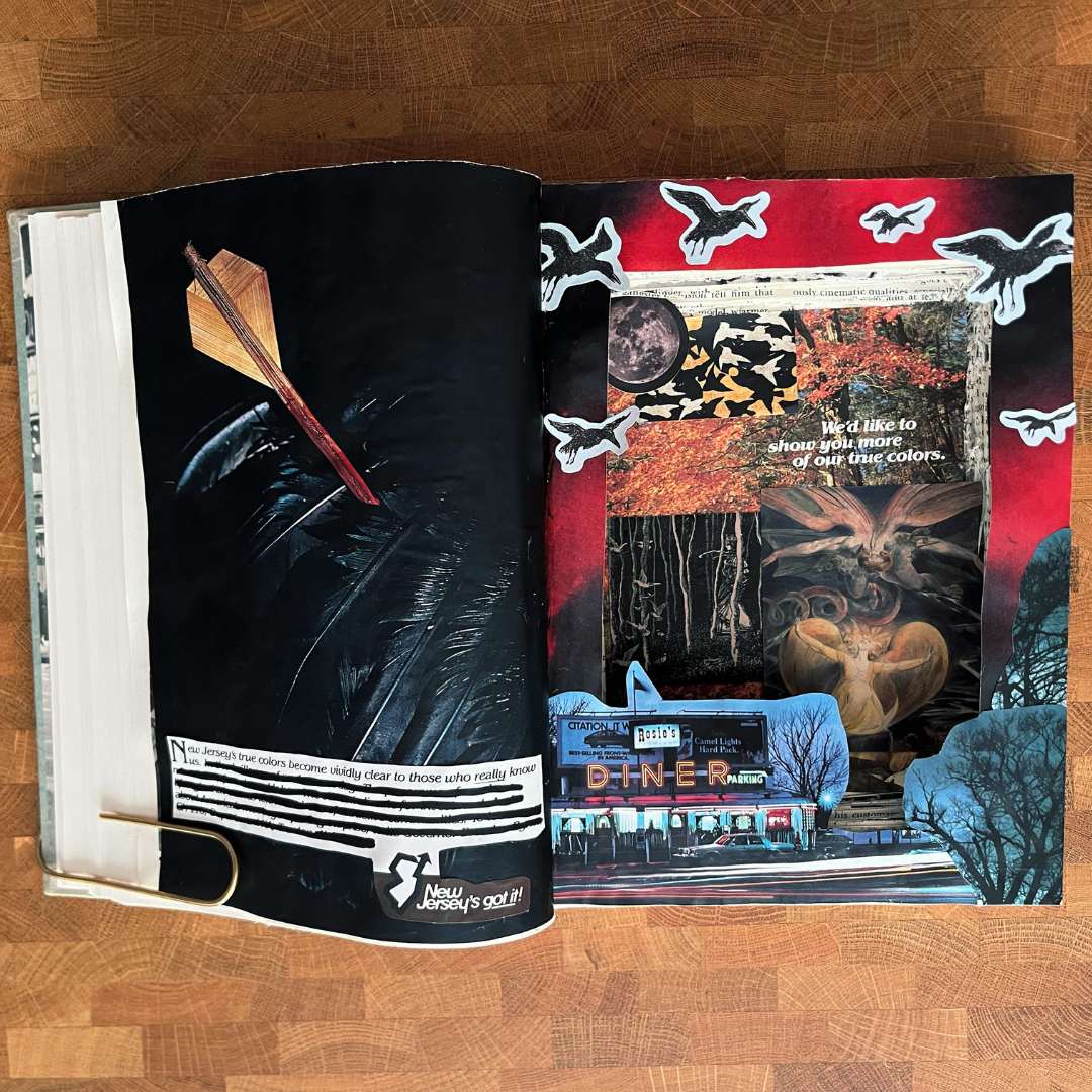 Open book with artistic illustrations on a wooden surface