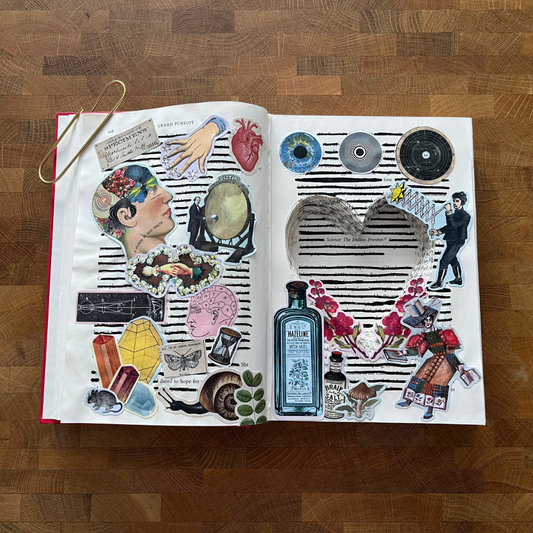 Open book with collage of illustrations on a wooden surface