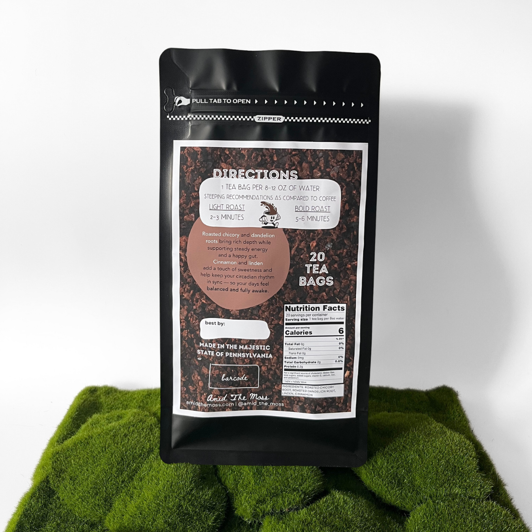 Black tea bag package with label on a green fabric background