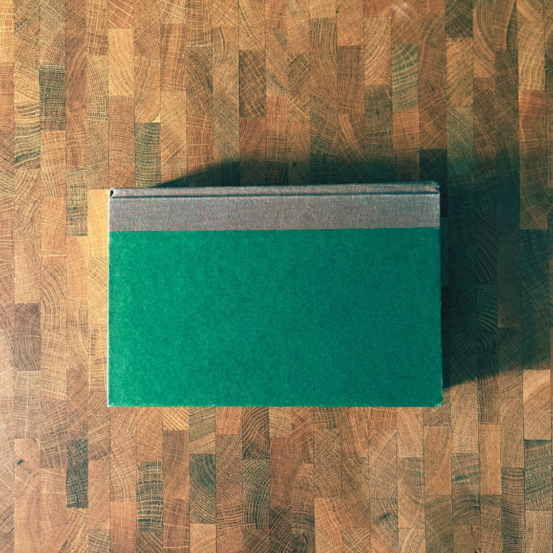 Green book on a wooden surface