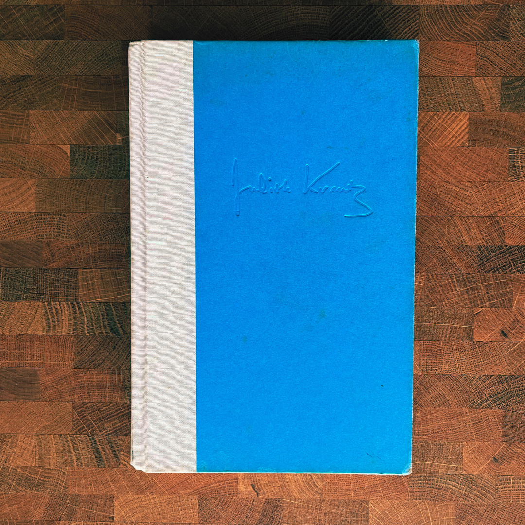 Blue notebook with white spine on a wooden surface