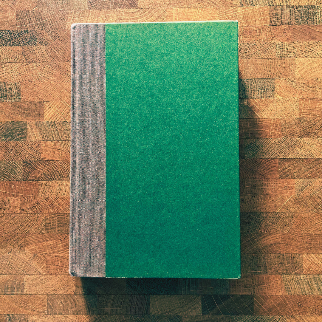 Green book on a wooden surface