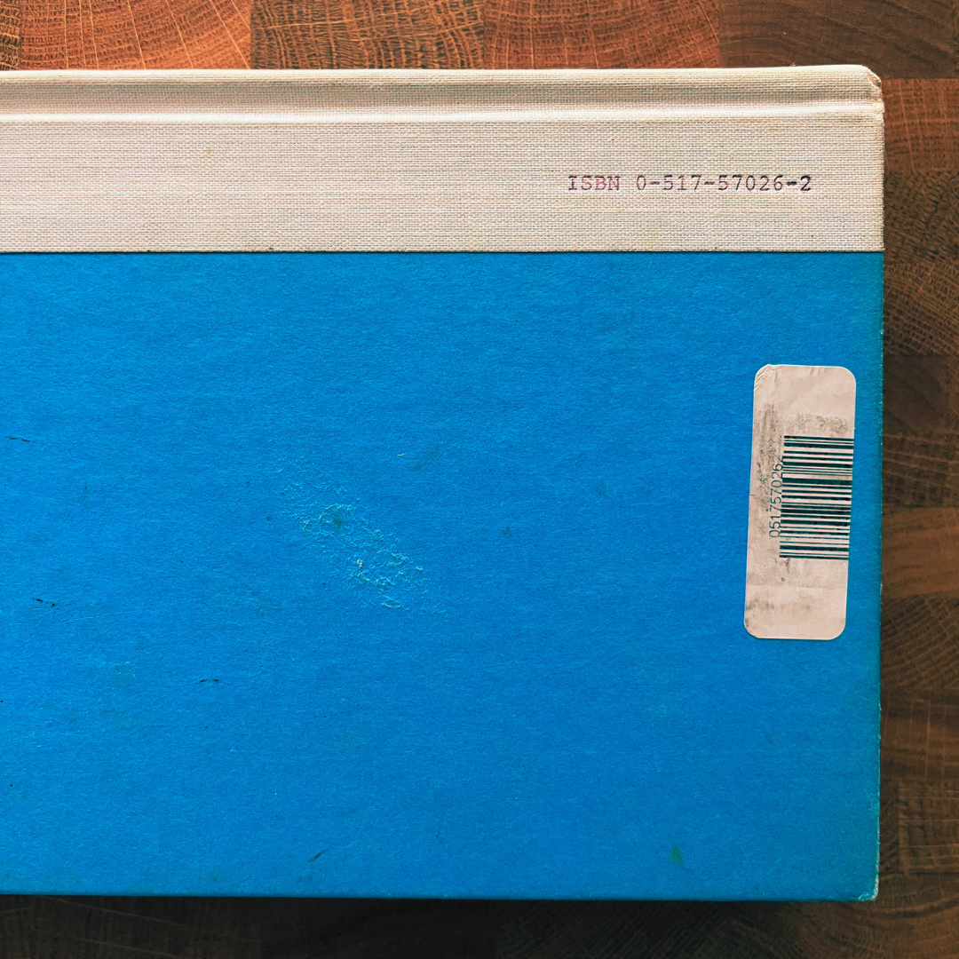 Blue book with a beige spine on a wooden surface