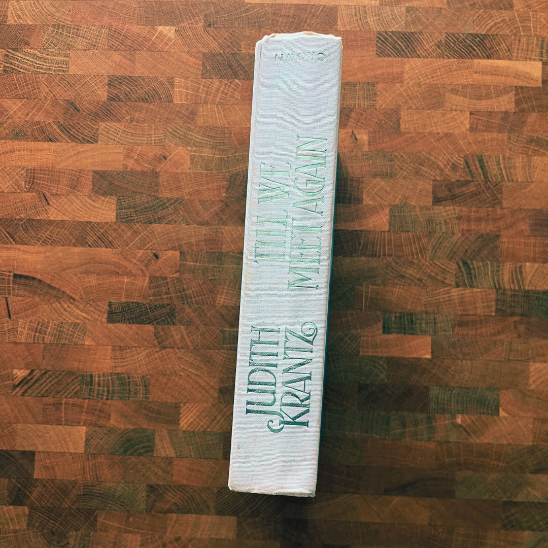 Book titled 'Let Us Meet Again' by Judith Kraniz on a wooden surface