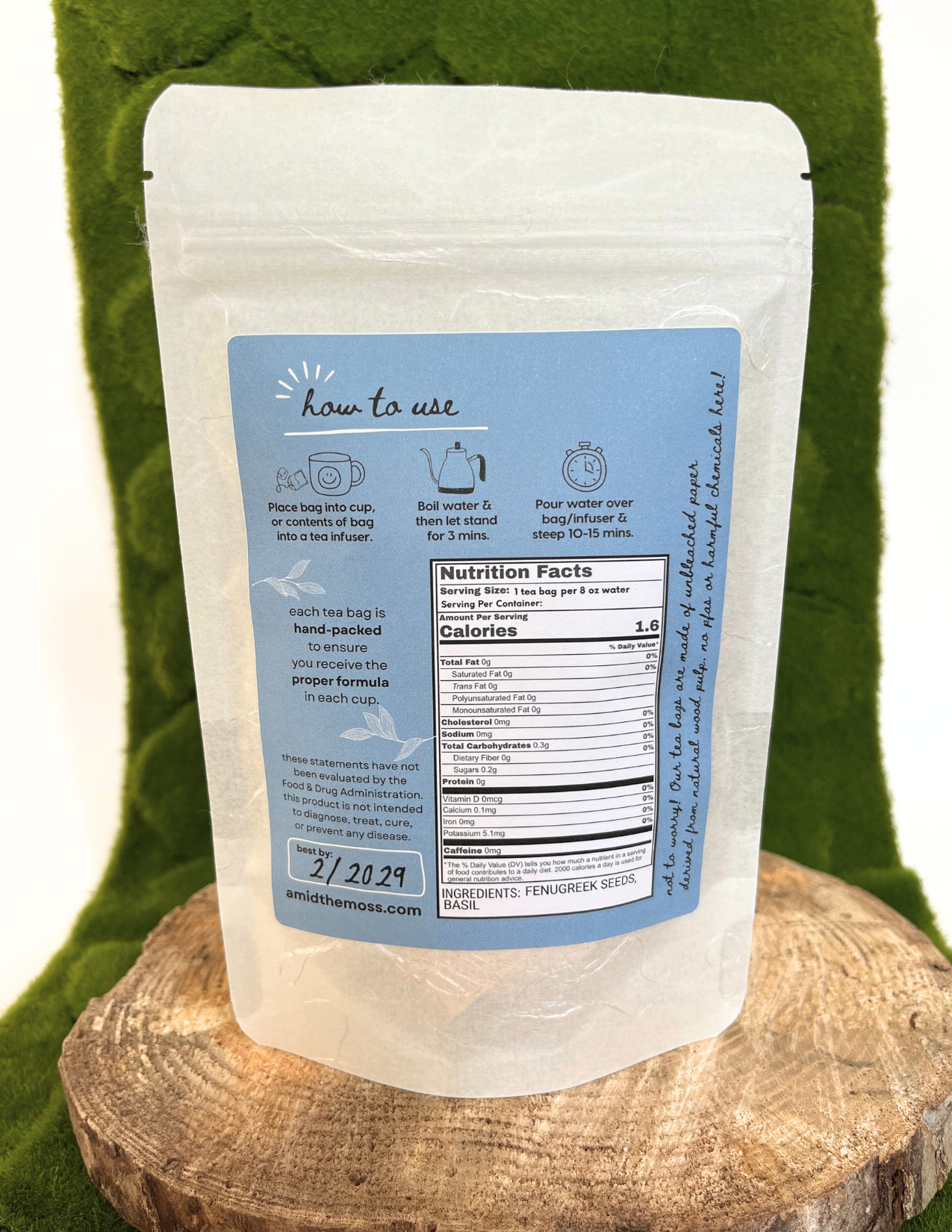 Tea bag packaging with a blue label on a wooden block against a green background