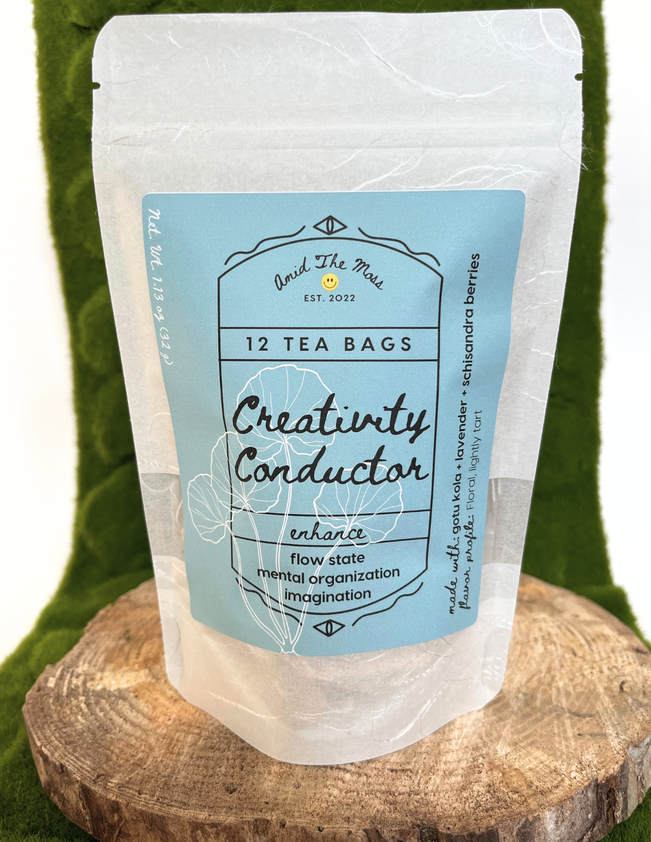 Tea bag package labeled 'Creativity Conductor' on a wooden surface with a green background