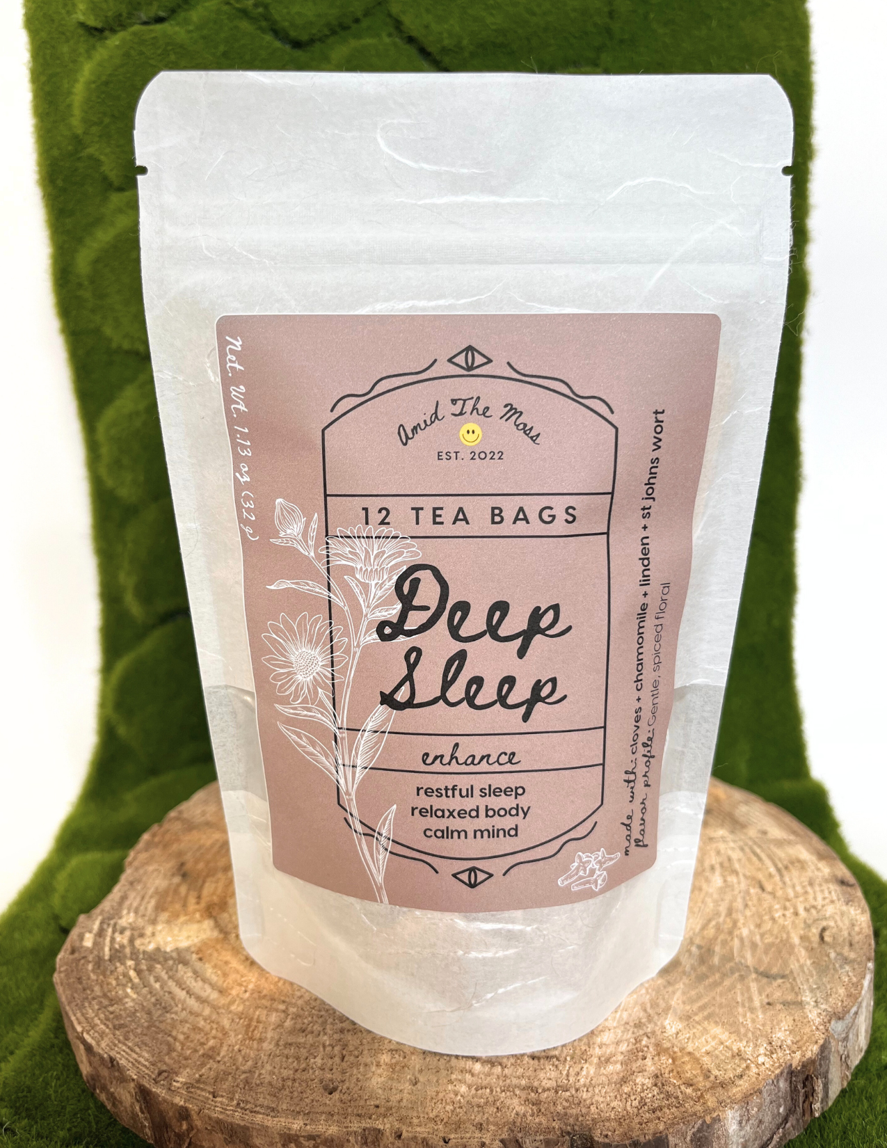 Tea bag packaging labeled 'Deep Sleep' on a wooden stand with a green leafy background
