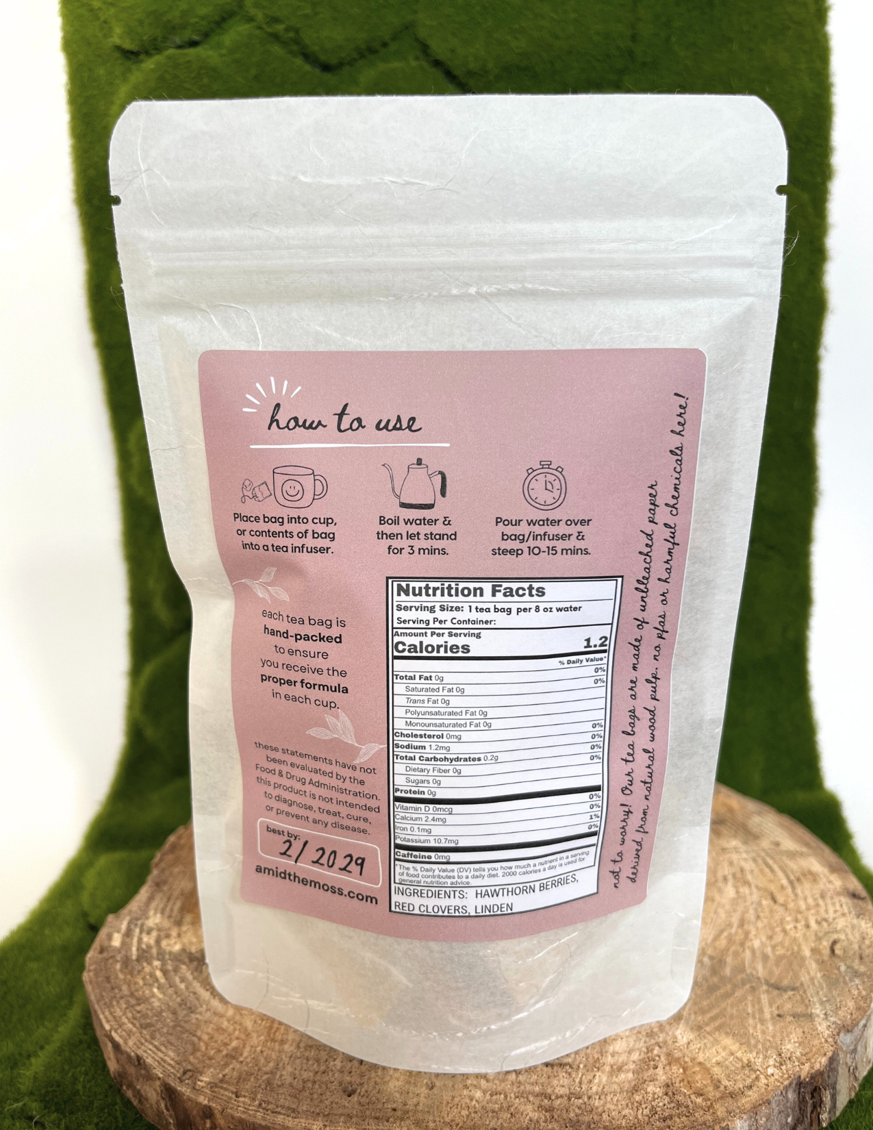 White packaging with pink label on a green fabric background