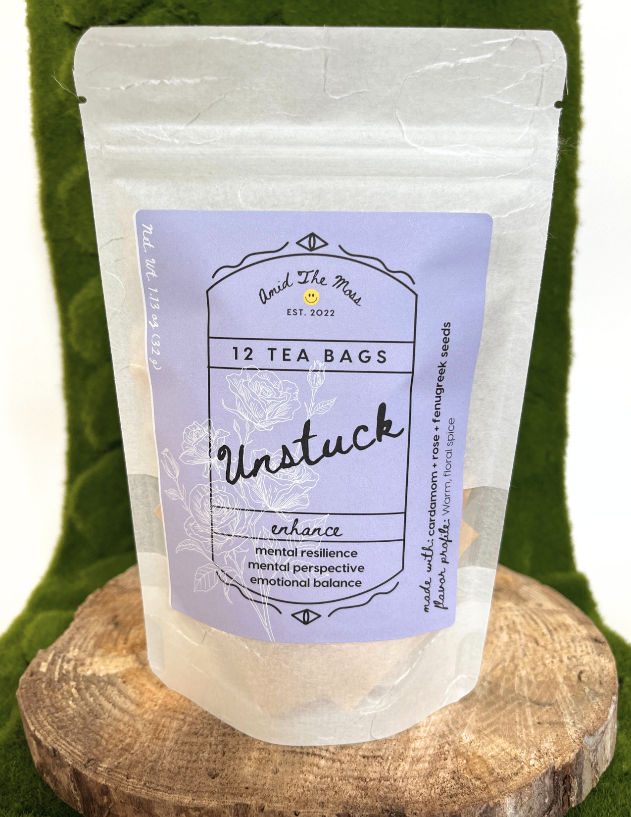 Tea bag package labeled 'Unstuck' on a wooden stand with a green background